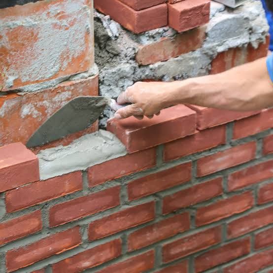 New brick course being bedded in fresh mortar